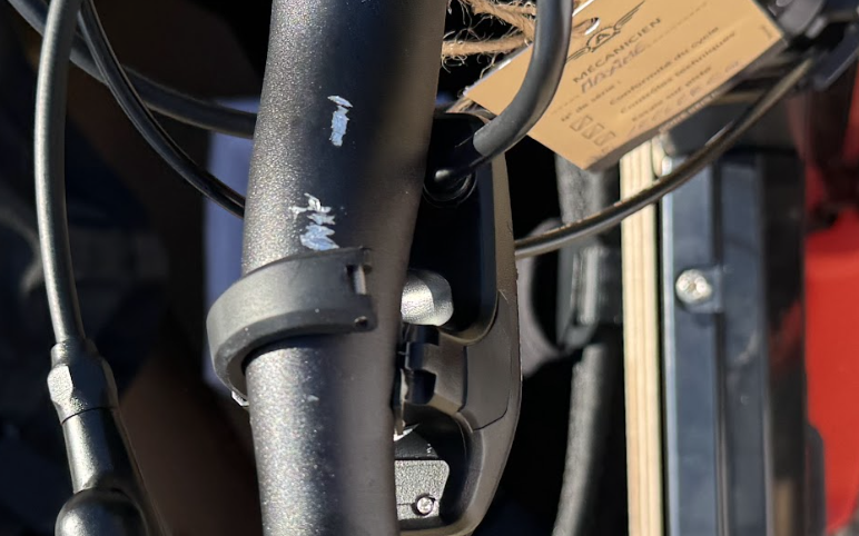 Paint chips on a frame tube near a cable clamp